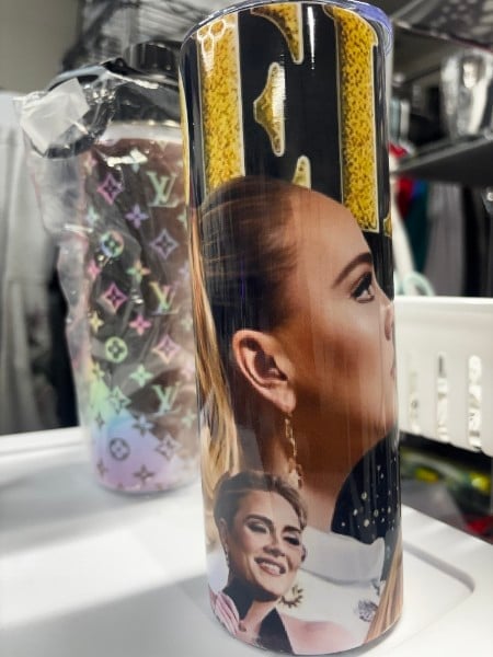 Custom printed tumbler featuring portrait photos of a smiling woman on black and yellow patterned design